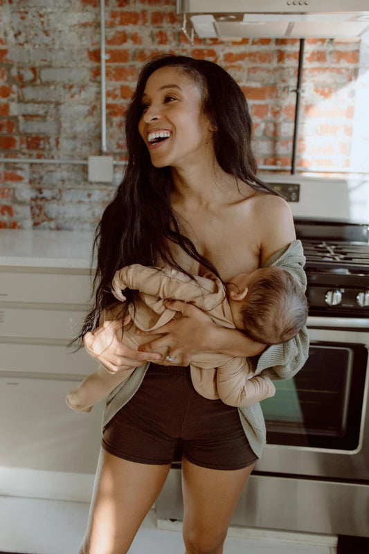 Mom breastfeeding her baby while practicing skin-to-skin contact. 