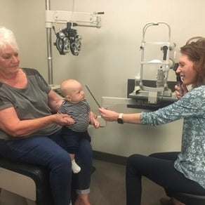Photo of Dana giving her baby an eye exam.